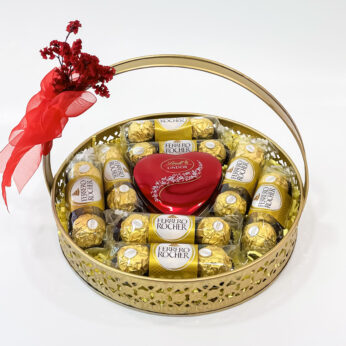 Radiant Wishes With Happy New Year Gift for Her – Lindt Lindor, Ferrero Rocher, and Delicate Blooms in a Brass Basket